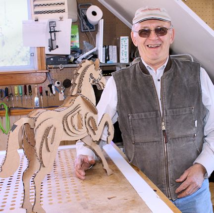Stan Kern poses with the cardboard horse he used to begin designing the plywood horse and then to the full-sized horse
